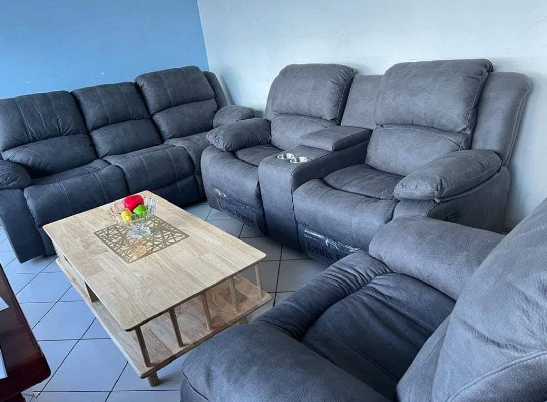 A grey fabric recliner sofa set with cup-holder console and a wooden coffee table, arranged in a living room at Homewood Furnitures