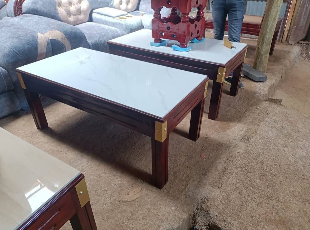 Mahogany coffee table and side table with white marble-look glass tops and brass corners